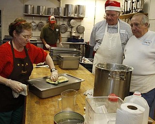 The Vindicator/Lisa-Ann Ishihara -- Nancy Jenkins of Warren,John Messersmith of Hartford and Pete Orfanos of Warren volunteer their time in the kitchen at Aulizio's Banquet Center in Warren for the free christmas dinner