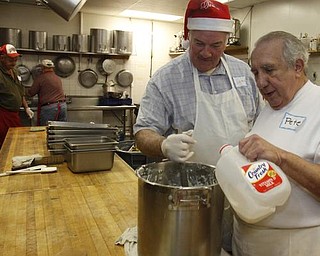 The Vindicator/Lisa-Ann Ishihara -- John Messersmith of Hartford and Pete Orfanos of Warren volunteer their time in the kitchen at Aulizio's Banquet Center in Warren for the free christmas dinner