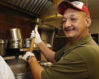 The Vindicator/Lisa-Ann Ishihara -- Rick Bowser of Andover volunteers his time in the kitchen at Aulizio's Banquet Center in Warren for the free christmas dinner
