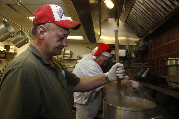 The Vindicator/Lisa-Ann Ishihara -- Rick Bowser of Andover volunteers his time in the kitchen at Aulizio's Banquet Center in Warren for the free christmas dinner
