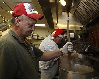 The Vindicator/Lisa-Ann Ishihara -- Rick Bowser of Andover volunteers his time in the kitchen at Aulizio's Banquet Center in Warren for the free christmas dinner