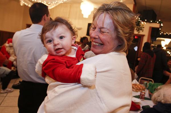 The Vindicator/Lisa-Ann Ishihara -- Aiden Strawderman (5 months) of Warren waits in his grandma's arms Betty Strawderman of Warren to see Santa at Aulizio's Banquet Center in Warren