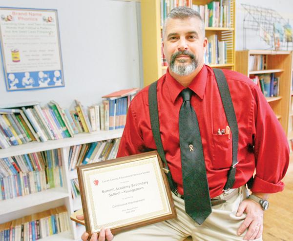 The Vindicator/Robert K. Yosay -----Ray Pallante  - proudly shows off his improvement in the state acheivement tests.. certificate at Summit Academy--  on Oak Hill in Youngstown 1222009