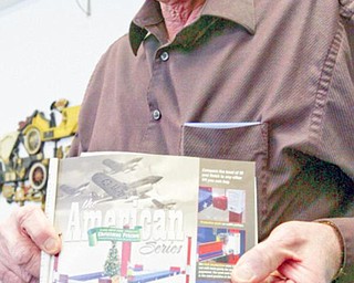 Owner of Backyard Buddy, Larry Gross, holds an ad for lifts for autos. He says cheap imports from China have hurt his business.