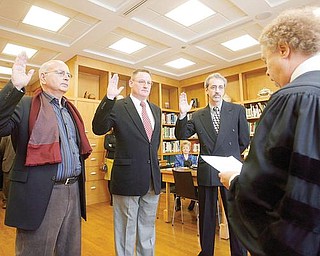 TAKING AN OATH: Judge Mark A. Belinky of Mahoning County Probate Court, foreground, swears in the new commissioners to the Mill Creek MetroParks Board. They are, from left, Daniel De Salvo of Boardman, John Ragan of Canfield and Dr. Robert Durick of Struthers. They were sworn in Wednesday. 