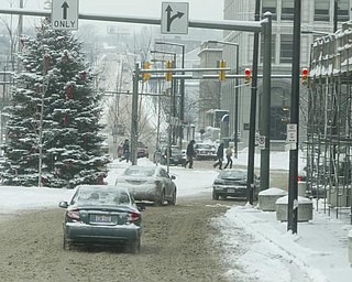 Motorists and pedestrians brave the elements in downtown Youngstown Friday morning.