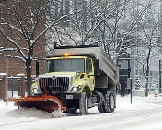 William D. Lewis/The Vindicator A snow plow makes it way along Federal St in downtown Youngstown Friday morning.
