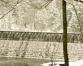 Water flows over the dam near the Pioneer Cabin in Mill Creek MetroParks.