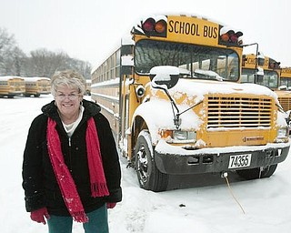 Judi Ebert, of Boardman, stands alongside a parking lot full of snow covered buses, after picking up her paycheck at the Youngstown Board of Education's Bus Depot on Friday afternoon. Ebert, a nine year veteran driver, and her fellow drivers had the day off on Friday with all or nearly all of Mahoning County's schools closed due to snow fall and freezing conditions. Despite having the day off, after picking up her check, Ebert was off to shuttle her friends children to the YMCA despite having the day off.