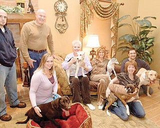 COMMON CAUSE: Some residents are trying to gather funds to build a dog park in Boardman Township Park. Standing are Jason Fellows and Richard Fabian. Sitting and kneeling, from left, are Jennifer Fellows with her chocolate Labrador Roscoe, Linda Fabian with her wirehaired terrier Abbey, Vicky Loree with her Italian greyhound Luigi, Abbey Loree with her boxer Izzy and Jason Loree with his Labrador Bowie.