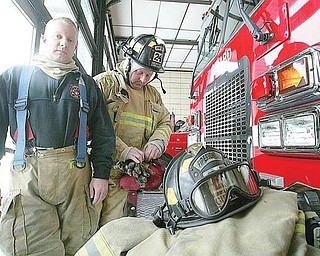 GEARING UP: Girard firefighters Jay Barnhart, left, and Nathan Walker III suit up in their regular gear, which is worn year-round. The headgear includes a hood of Nomex, a registered trademark for flame-resistant material. Firefighters said they sometimes wear thermal underclothes when outside temperatures are low.