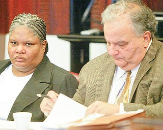 ON TRIAL: Monique Williams of Youngstown sits at the defendant’s table in Mahoning County Common Pleas Court. She is on trial in the death of her husband, Julius. Seated next to her Thursday was her lawyer, Atty. Thomas E. Zena.