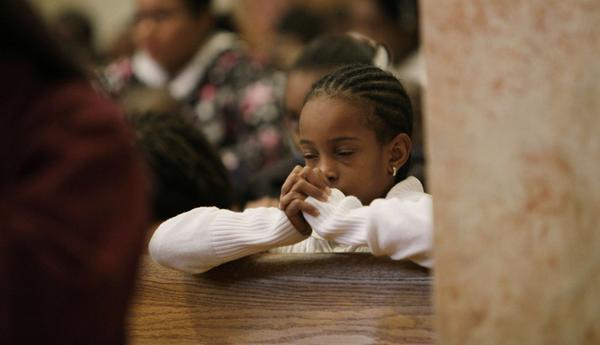 Mitchell Monroe prays for the victims of the Haiti's earthquake during a mass at the Cathedral of St. Mary's Wednesday Jan. 13, 2010, in Miami, Fla.'s Haitian community. (AP Photo/J. Pat Carter)