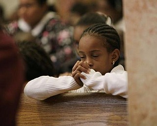 Mitchell Monroe prays for the victims of the Haiti's earthquake during a mass at the Cathedral of St. Mary's Wednesday Jan. 13, 2010, in Miami, Fla.'s Haitian community. (AP Photo/J. Pat Carter)