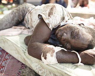 An earthquake survivor lies on a matt on a street of Port-au-Prince, Thursday, Jan. 14, 2010.