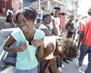 Girls cry as a little girl is removed from the rubble, Wednesday, Jan. 13, 2010, in Port-AU-Prince, Haiti. Tuesday's quake left a landscape of collapsed buildings _ hospitals, schools, churches, ramshackle homes, even the gleaming national palace _ the rubble sending up a white cloud that shrouded the entire capital.