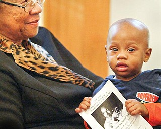 STARTING YOUNG: Daniel Harris, 1, of Youngstown takes in a community worship service to honor the Rev. Martin Luther King Jr. He was sitting in the lap of Louise Sullivan as his mother sang in the choir Sunday. The service was at Elizabeth Missionary Baptist Church in Youngstown.
