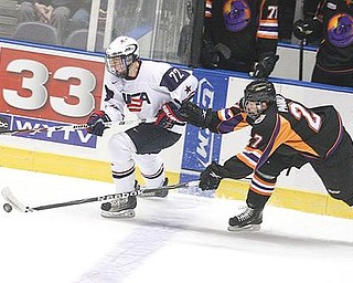 I’LL TAKE THAT: Ben Paulides (27) of the Youngstown Phantoms tries to keep the puck from Team USA’s Austin Wuthrich during Monday’s game at the Covelli Centre. The Phantoms won 7-3.