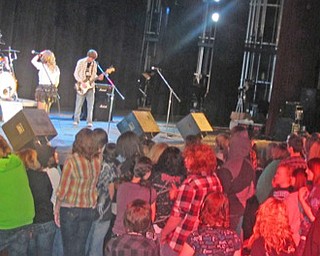 Students crowd the stage at the Boardman Performing Arts Center as the band The Other Night performs. The band, consisting of four members, are all Boardman High School students.