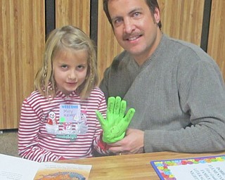 Reading is fun when you can make personalized gloves to wear. Molly Malmer (left) sits with her father, Mike Malmer, and shows off the reading glove that she made. 