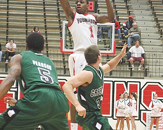 PENGUINS GO COLD: Youngstown State’s DeAndre Mays (1) launches a pass over Green Bay Phoenix defenders during Sunday’s game at YSU’s Beeghly Center.  After playing a solid first half, the Penguins’ offense went cold, and YSU dropped its fourth-straight game, 69-55.
