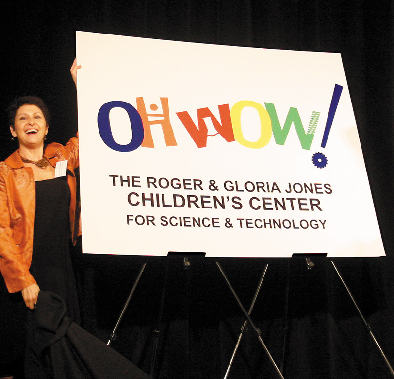 NEW LOGO: Suzanne Barbati, executive director of “OH WOW!” The Roger & Gloria Jones Children’s Center for Science & Technology, unveils the new logo for the former Children’s Museum of the Valley. The center has launched a $1.5 million campaign to remodel and furbish its new home, the former McCrory Building in downtown Youngstown.