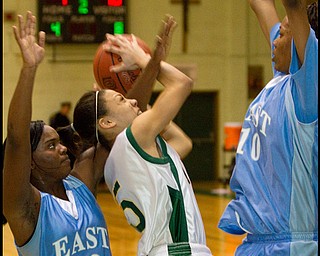 The Vindicator/Geoffrey Hauschild.Ursuline's Aurielle Irizzary (5) takes a shot while defended by East's Lesa Monet Oliver (22) and Briana Dawson (10) during the second quarter of a game at Ursuline High School on Thursday evening.