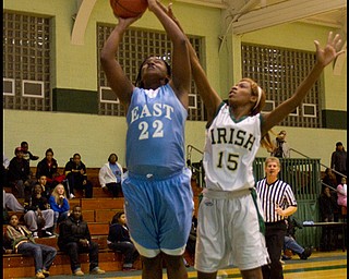 The Vindicator/Geoffrey Hauschild.East's Lesa Monet Oliver (22) scores two while defended by Ursuline's Dominique Jenkins (15) during the third quarter of a game at Ursuline High School on Thursday evening.