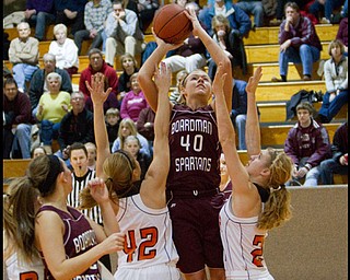 The Vindicator/Geoffrey Hauschild.Boardman's Kayleigh Lipke (40)shoot over top of Hoover's Alyssa Chovan (42) and Lindsey Fiala (24) during the third quarter of a game at Hoover High School on Saturday afternoon.