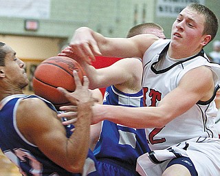 The Vindicator/Geoffrey Hauschild.Struther's Nate Jacubee(12) wrestles Hubbard's Chase Myers (22) Corey Groscost (15) for the ball looking for a rebound during the fourth quarter of a game at Struthers High School on Friday evening..