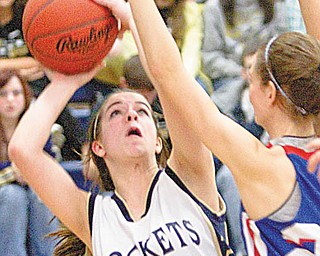 Lowellville's Kelley Hunes (21) takes a shot from beneath the basket past Western Reserve's Hannah Shrader (20) during the fourth quarter of a game at Lowellville High School on Monday evening.