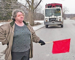 STOP AHEAD: Anna McCollums of Hillsville, Pa., uses a flag to stop a truck entering the Carbon Limestone Landfill operated by Republic Services. She and a group of concerned citizens are using flags to make trucks leaving and entering the facility stop at the stop signs.