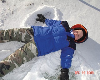 Preston English of Boardman, 41Ú2, makes snow angels in the snow..