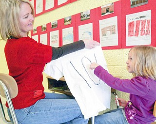 PARENTAL HELP: Deanna McIntosh, a parent volunteer at Joshua Dixon Elementary School in Columbiana, helps her daughter, Mandy, with a T-shirt project at school. Deanna is one of more than 60 parent volunteers at the school.