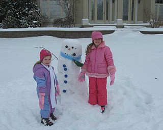 Alyssa Dill, 6, along with her sister Camie Dill, 3, have some winter time fun building a snowman at their house in Canfield. It was a great way to spend the day off of school.