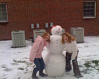 Friends Annamarie Duda, of Berlin Center, and Raquel Markulin, of Canfield, build a snowman together.