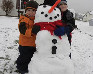 Brothers Braden Butler, 5, and Evan Butler, 3, of New Middletown built their first snowman. .