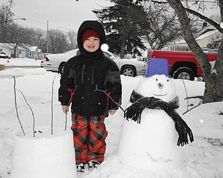 Vincent Dominic from Youngstown shows off his snow birthday cake and his first snowman..