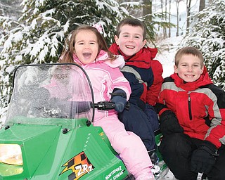 Lauren, Christopher and Bobby Smallwood, all of Canfield., take time out for a photo while riding their snowmobile..