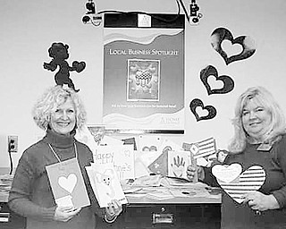 HEARTS FOR HEROES
Special to The Vindicator
LOTS OF LOVE: More than 1,000 valentines are being sent to Maj. Christine Blice-Baum, a U.S. Army chaplain in Iraq, who will distribute them to men and women serving in the military. The valentines are a part of a Heart for Heroes project conceived by Nancy Cuffle, a Realtor with RE/Max Valley Real Estate, to keep soldiers from feeling lonely. As word of her idea spread and others became involved, Home Savings designated its YSU-Kilcawley and main offices as drop-off sites for the valentines. A few of the valentines are displayed by, from left, Cuffle and Jeanne Watson-Antol, sales and service manager at the YSU Kilcawley office. They were created and donated by students at Wee Care Day Care, at South Range, Poland, McDonald, Canfield and Boardman schools, at YSU, and by employees of Home Savings and residents at Park Vista Retirement Center.
