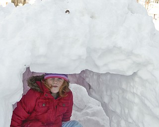 The Vindicator/Lisa-Ann Ishihara--- Emily Evans (5) of Austintown sits in the fort her father helped make, while her brother Tyler (10) packs more snow above.