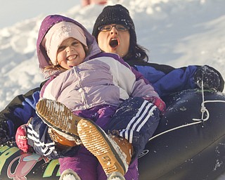 The Vindicator/Lisa-Ann Ishihara--- Cindy Bakos of Austintown and her daughter Kylie (5)  slide down the hill in the snow at Mill Creek Park's  Wick Recreation Area .