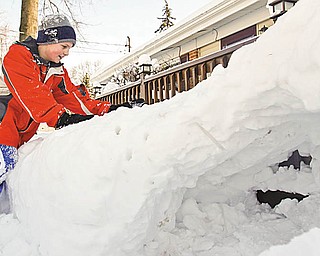 Tyler Evans (10) of Austintown packs more snow on top of the fort his father help him make.