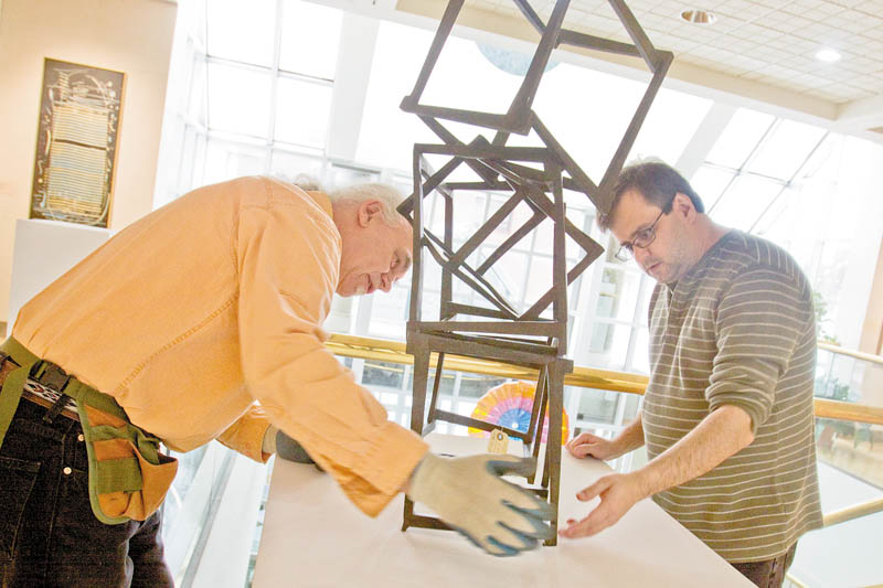 MEN AT WORK: Ed Hallahan, left, and Wayne Grover, workers at the Butler Institute of American Art on Wick Avenue, Youngstown, help stabilize Jedd Novatt’s artwork. The art museum is a good place to spend time on a Valentine’s Day date. The daily admission cost: free.