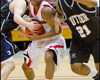 The Vindicator/Geoffrey Hauschild.YSU's Vance Cooksey (4) struggles past Butler's Zach Hahn (3) and Willie Veasley (21) and is ultimately fouled during the second half of a game at YSU's Beeghley Center on Thursday evening.