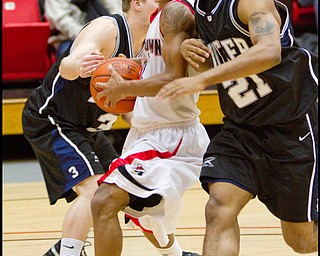 The Vindicator/Geoffrey Hauschild.YSU's Vance Cooksey (4) struggles past Butler's Zach Hahn (3) and Willie Veasley (21) and is ultimately fouled during the second half of a game at YSU's Beeghley Center on Thursday evening.