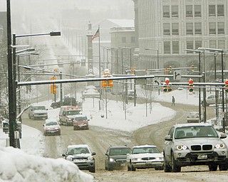 WINTER WOES: Snow did not let up all day Wednesday, creating challenges for road crews and motorists, such as those motoring on Wick Avenue near Youngstown State University.