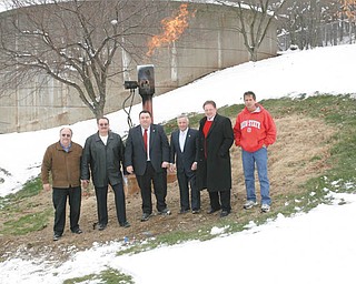 FREE FUEL: Officials stand in front of a flame of methane gas at the Struthers waste-treatment plant. The city and Mahoning County will save money when two new generators capture the methane and use it to power the plant. From left are: Gary DiOrio of MS Consultants, which designed the project; Tony Fire, 1st Ward councilman; county commissioners Anthony Traficanti and David Ludt; Struthers Mayor Terry Stocker; and plant manager Bob Gentile.