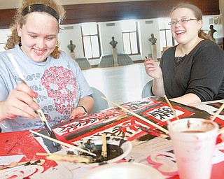 ANTI-PARTYING: Emerald Collins, 15, and Aree Adams, 14, both of Niles, paint during an anti-Valentine’s Day party at the William McKinley Memorial Library in Niles on Thursday afternoon.