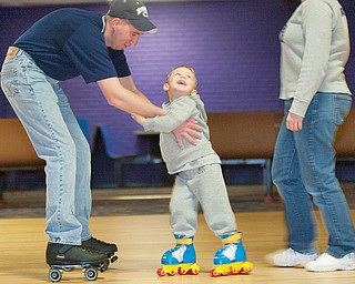 The Vindicator/Geoffrey Hauschild.Jodi Sweeney and Carl Bond, of Boardman, help their son, Jordan Bond, 3, use the roller skates he received as a Christmas gift at a rink for the first time at Skate Zone in Austintown on Thursday afternoon..1.21.2010.Skate Zone InFocus
